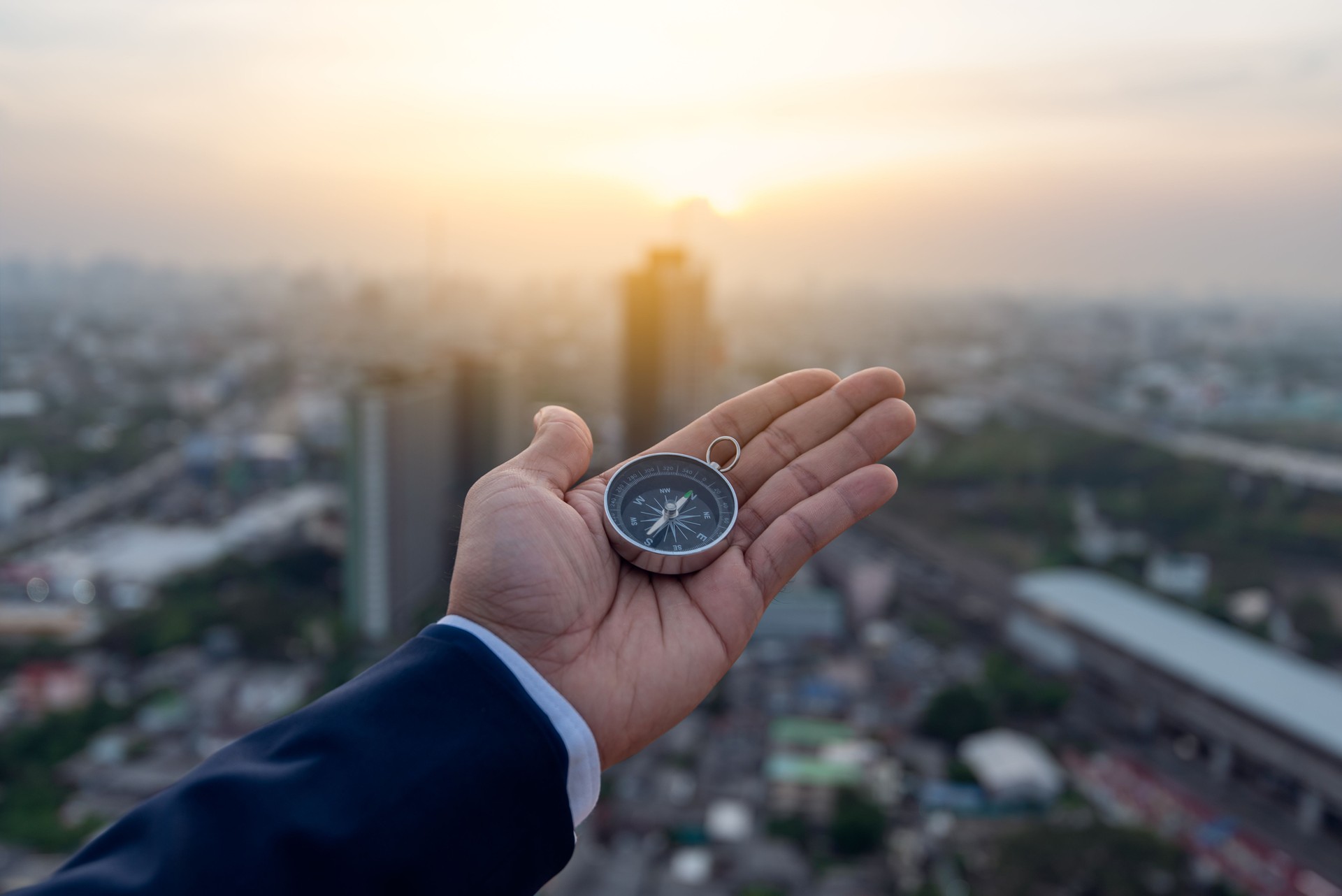 Businessman holding a navigation compass in hand and define marketing direction, Abstract business